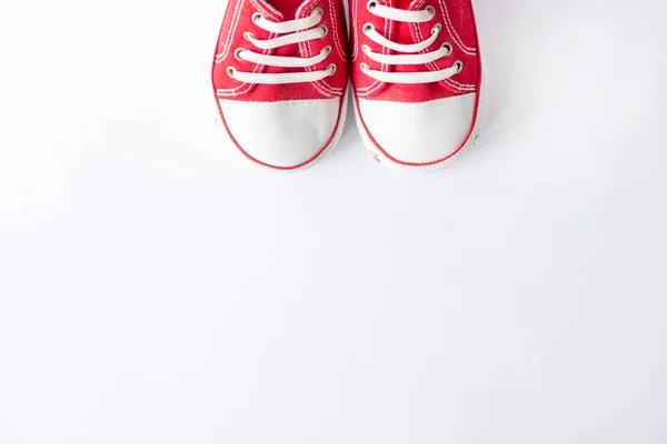 Cute red small sized canvas shoes top view on white background with copyspace