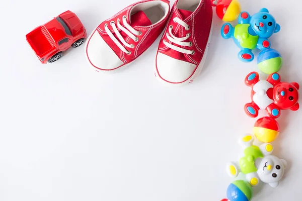 Mesa vista superior decoración niños juguetes coches para desarrollar fondo concept.Flat lay bebé zapatos rojos — Foto de Stock