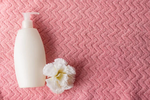 Spa i rosa färg koncept på rosa bakgrund. vit flaska, Flat Lay Style. ovanifrån på vit blomma och sprayflaska — Stockfoto