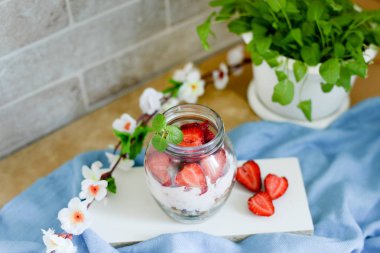 Beyaz ve mavi kırsal arka planda renkli meyve salatası. Üst manzara. Çilekli milkshake ve çiçekler.
