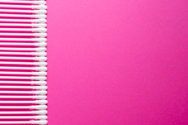 Plastik kazmalı bireysel kulak çubukları ve pembe arka plana odaklı pamuk tomurcukları. Kulak temizliği için temiz kulak temizliği. Temizlik kulak kiri için steril yumuşaklık uygulayıcısı