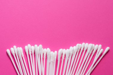 Pembe arka planda pamuk tomurcukları. Fotokopi alanı ile kozmetik konsept. Tıp ve kişisel hijyen. Metin için yer.