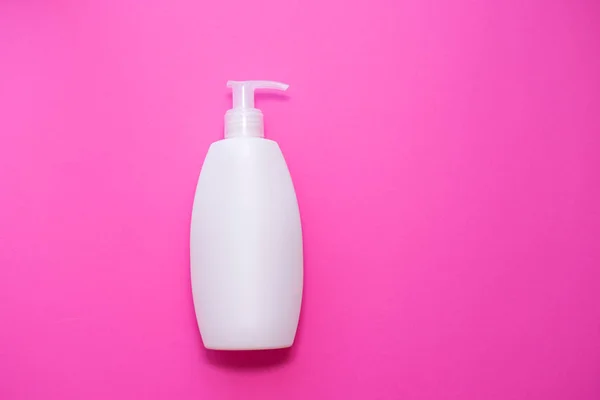 Bianco Spray bottiglia di plastica su sfondo rosa. pelle, cura del corpo. copia lo spazio. posto per testo — Foto Stock