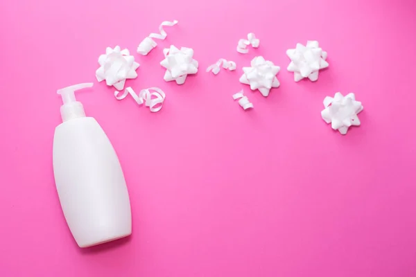 Spa σε ροζ χρώμα Concept σε ροζ φόντο. λευκό μπουκάλι, επίπεδο στυλ Lay. φροντίδα δέρματος και σώματος. πάνω όψη του λευκού λουλουδιού και φιάλη ψεκασμού — Φωτογραφία Αρχείου