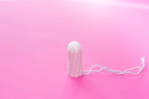 Medical female tampon on a pink background. Hygienic white tampon for women. Cotton swab. Only one tampon on a pink background. copy space — Stock Photo, Image