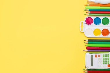 Sarı arka planda okul malzemeleri ve bir kopya alanı