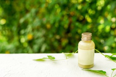 Doğal arkaplanda ginseng bulunan doğal organik krem şişesi.