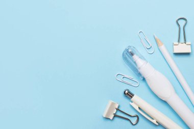 Mavi arka planda beyaz ve mavi ofis malzemeleri.