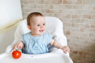 Anaokulunda sağlıklı beslenen tatlı bir kız çocuğu. Sandalyedeki bebek. Boşluğu kopyala