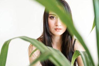 Yeşilliği olan güzel bir kadının portresi. Yaz moda fotoğrafı. Cilt bakımı konsepti, güzellik merkezi, biyolojik ürün