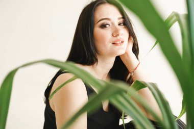 Fotokopi alanı olan beyaz arka planda yeşilliği olan bir kadın. Yaz moda fotoğrafı. Cilt bakımı kavramı