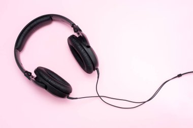 Pembe arka planda siyah kulaklıklar