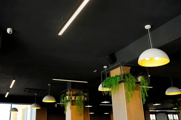 Ceiling lighting fixture lamps hanging along the curved in modern cafe