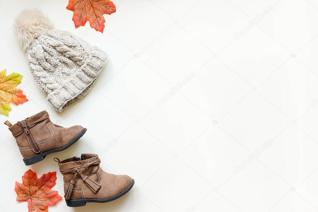Flat lay of baby autumn clothing, light background with copy space