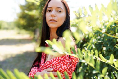 Yeşil arka planda kırmızı elbiseli güzel bir kadının portresi..