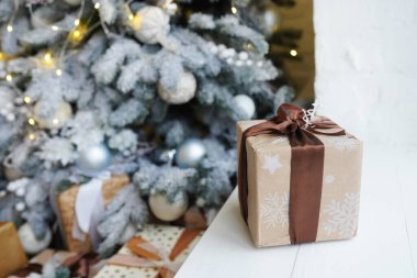 Noel ağacının yanındaki pencerede yeni yıl hediyesi, ev dekorasyonu.