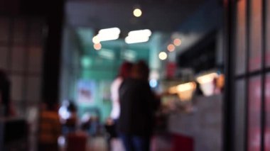 Kafede insanların oynadığı bulanık bir sahne.