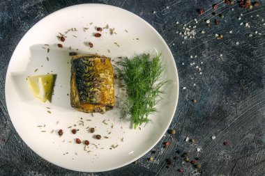 limon ve sebze ve karanlık bir arka plan üzerine dereotu ile fırında uskumru