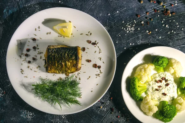 limon ve sebze ve karanlık bir arka plan üzerine dereotu ile fırında uskumru