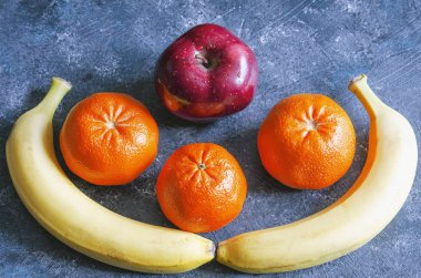 muz mandalina ve mavi arka plan üzerinde kırmızı elma