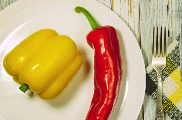 Sweet red pepper in a top view Red and yellow sweet pepper on a white plate. vegan food