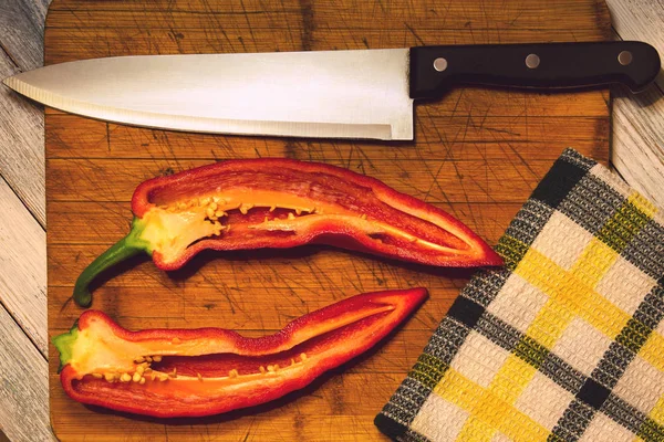 Sebze vejetaryen için-tatlı kırmızı biber bir kesme tahtası üzerinde keskin bir bıçak yanındaki ince dilimler halinde kesin. Sağlıklı gıda, izole. Yakın çekim.