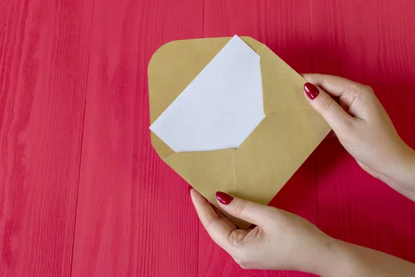 letter of female hands on red wooden background