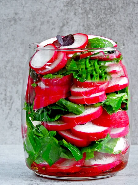 Salad in the jar. Fitness salad with radish and spinach. Food containing fiber.