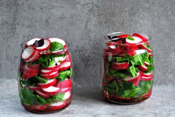 Salad in the jar. Fitness salad with radish and spinach. Food containing fiber.