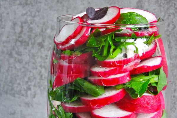 Salad in the jar. Fitness salad with radish and spinach. Food containing fiber.