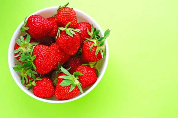 A bowl with strawberries on a bright background. Food modern. Food minimalism.