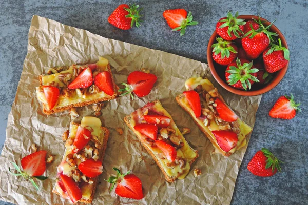 Sandwiches with strawberries, walnuts and melted cheese. Toasts with strawberries and cheese.