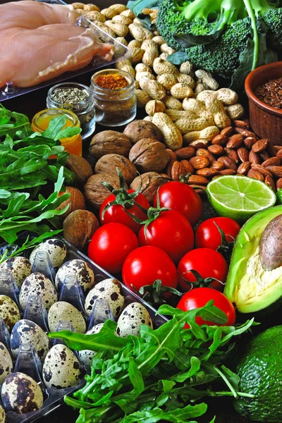 Ketogenic diet concept. A set of products of the low carb keto diet. Green vegetables, nuts, chicken fillet, flax seeds, quail eggs, cherry tomatoes. Healthy food concept. Keto diet food frame.