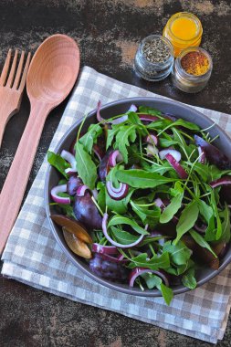 Sağlıklı Roka Salatası, Erik ve mavi şık eski püskü arka plan üzerinde bir kapta soğan. Erik salata bir kase vegan. Erik Roka Salatası. Doğru beslenme kavramı.