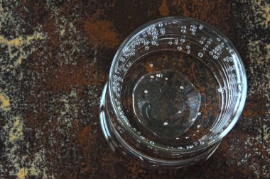 Islak bir yüzey üzerinde mineral içme suyu bir bardak.