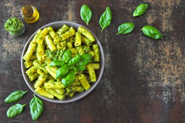 Pesto ve fesleğen ile iştah açıcı makarna. Pesto makarna ile vegan kase. Pesto soslu makarna çeşitleri. Taze fesleğen yaprağı.