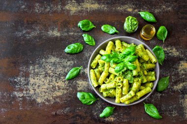 Pesto ve fesleğen ile iştah açıcı makarna. Pesto makarna ile vegan kase. Pesto soslu makarna çeşitleri. Taze fesleğen yaprağı.