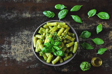 Pesto ve fesleğen ile iştah açıcı makarna. Pesto makarna ile vegan kase. Pesto soslu makarna çeşitleri. Taze fesleğen yaprağı.