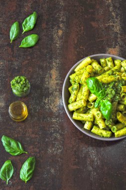 Pesto ve fesleğen ile iştah açıcı makarna. Pesto makarna ile vegan kase. Pesto soslu makarna çeşitleri. Taze fesleğen yaprağı.
