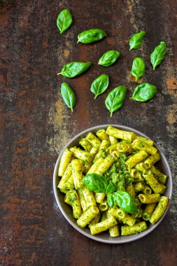 Pesto ve fesleğen ile iştah açıcı makarna. Pesto makarna ile vegan kase. Pesto soslu makarna çeşitleri. Taze fesleğen yaprağı.