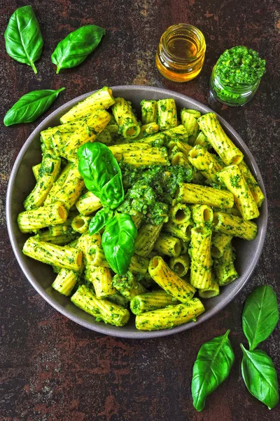 Pesto ve fesleğen ile iştah açıcı makarna. Pesto makarna ile vegan kase. Pesto soslu makarna çeşitleri. Taze fesleğen yaprağı.