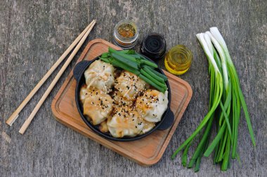 Soya sosu ve dökme demir tavada yeşil soğan ile mantı. Çin köfte.