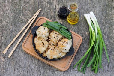 Soya sosu ve dökme demir tavada yeşil soğan ile mantı. Çin köfte.