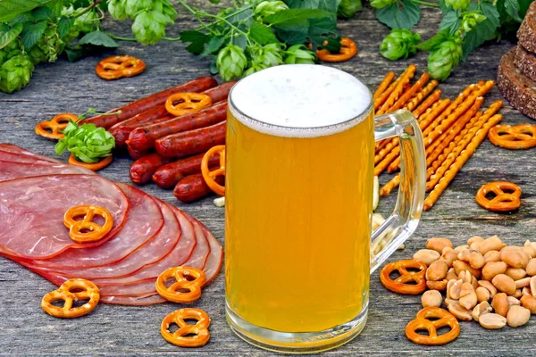 Oktoberfest food menu. Sausages, beer snacks, pretzels, a glass of beer on a wooden background. Oktoberfest mood.