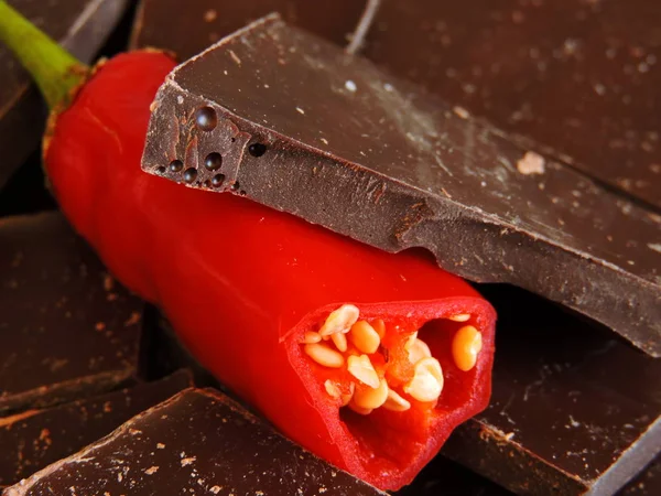 Pieces of chocolate and chili pieces. Broken pieces of chocolate with chili pepper.