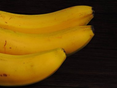 Koyu arkaplanda parlak sarı muzlar. Makro.