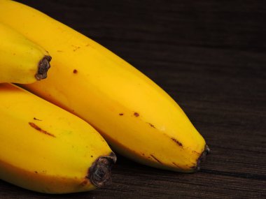 Koyu arkaplanda parlak sarı muzlar. Makro.