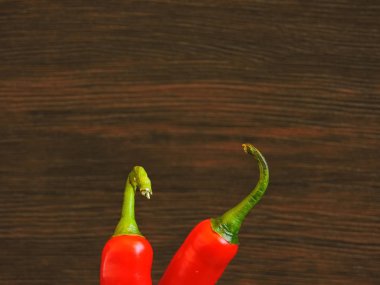 Koyu arkaplanda iki parlak biber. Boşluğu kopyala.