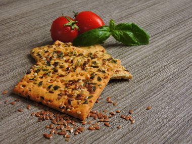 Keten tohumlu fitness kurabiyeleri. Kirazlı domates ve fesleğen. Gri ahşap arka plan. Boşluğu kopyala.