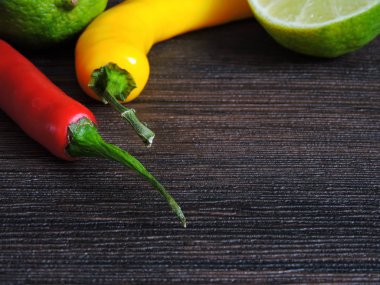 Koyu arkaplanda sarı ve kırmızı biber ve kireç.